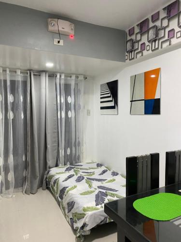 a bedroom with a bed and a green table at Burnham Hill Condominium EC Accomodation in Baguio