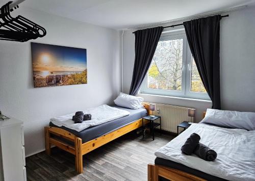 a room with two beds and a window at Cozy apartments in Halle in Nietleben