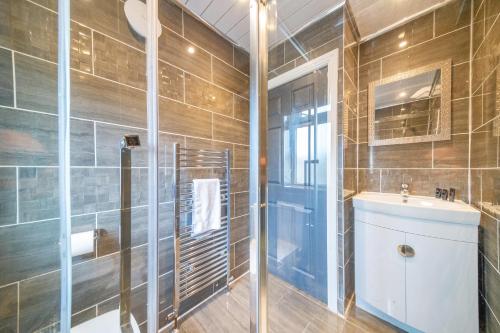 a bathroom with a shower and a sink and a mirror at *RB75L* For your most relaxed & Cosy stay + Free Parking + Free Fast WiFi * in Hunslet