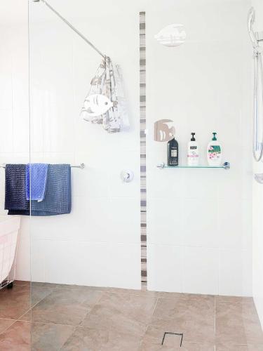a shower with a glass door in a bathroom at Serene 4Bed2Bath House w Parking Near Mornington Peninsula in Frankston