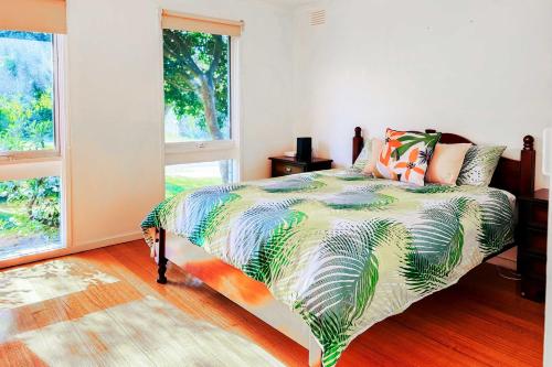 a bedroom with a bed with a colorful comforter at Serene 4Bed2Bath House w Parking Near Mornington Peninsula in Frankston