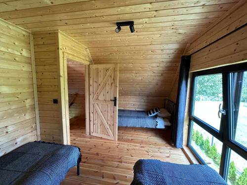 a room with two beds in a wooden cabin at Stodoły na Mierzei in Kąty Rybackie