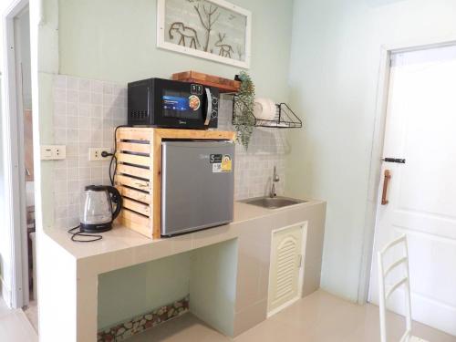 a kitchen with a sink and a microwave on a counter at 888 private room near khaoyai in Mu Si