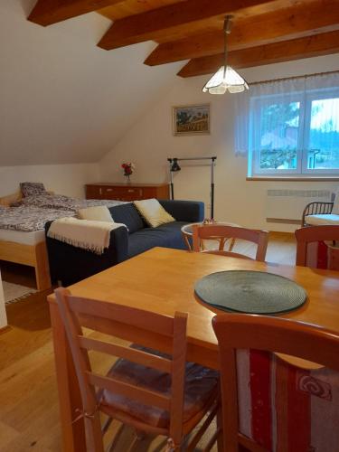 uma sala de estar com uma mesa e um sofá em Apartmán u potoka em Nové Město na Moravě