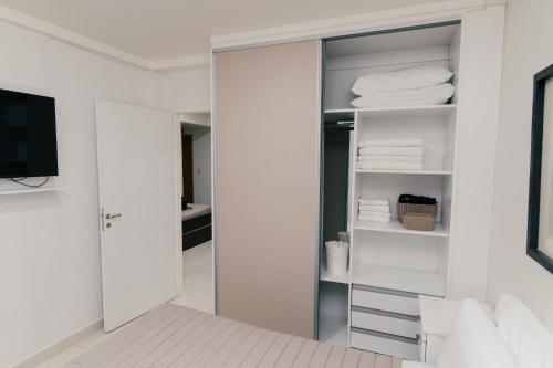 a room with a closet with white towels and a television at Departamentos Patagonia in Ushuaia
