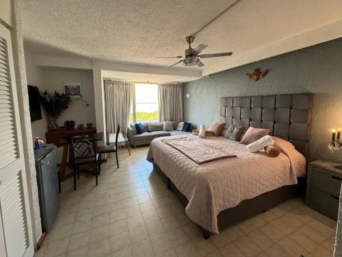 ein Schlafzimmer mit einem Bett und ein Wohnzimmer in der Unterkunft Spectacular Beach Romantic Sunset Lagoon View Studio in Cancún