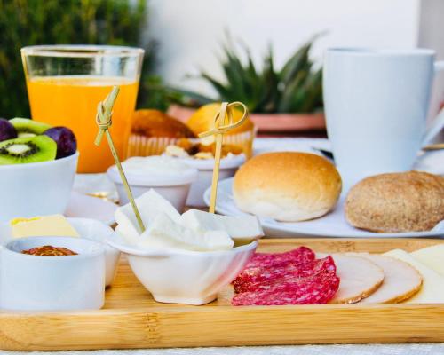una bandeja de comida con queso y otros alimentos en una mesa en Hostal Almares en Pichilemu