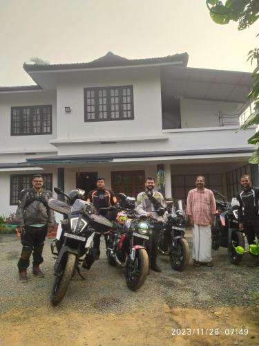 a group of men standing in front of a house with motorcycles at Sahyadri Homestay wayanad in Kalpetta