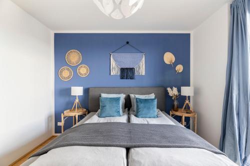 1 dormitorio con paredes azules y 1 cama con almohadas azules en EDLER WOHNRAUM Panoramablick 3 Schlafzimmer mit Boxspringbetten Klimaanlagen Kaffeevollautomat & Tiefgarage mit E-Ladestation, en Graz