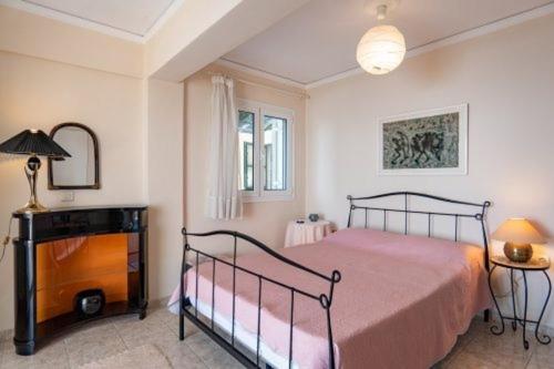 a bedroom with a bed and a table and a lamp at Atena Mare Sea View in Perama