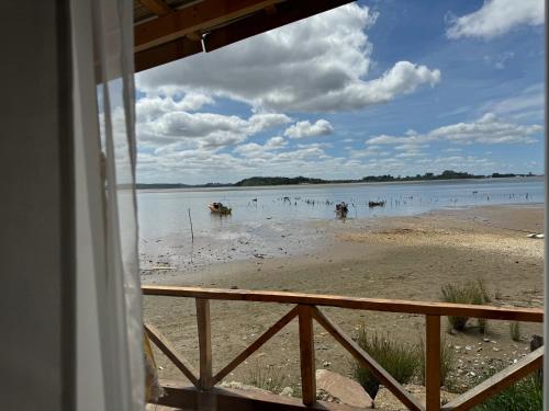 a view of a beach with people in the water at Cabañas y Tinajas Rio Quenuir in Maullín