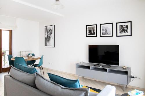 a living room with a couch and a tv at Ballatoio Apartment by the Lake in Lesa