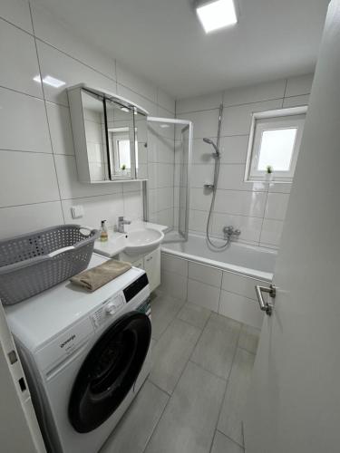 a white bathroom with a washing machine in it at Apartment Vlora 2-Naturblick in Villach
