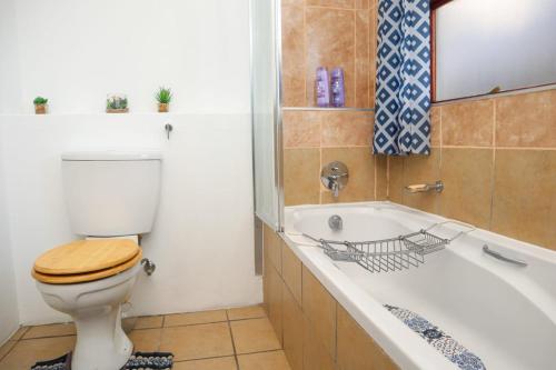 a bathroom with a toilet and a bath tub at Spacious and luxury 3 bedroom apartment in Midrand