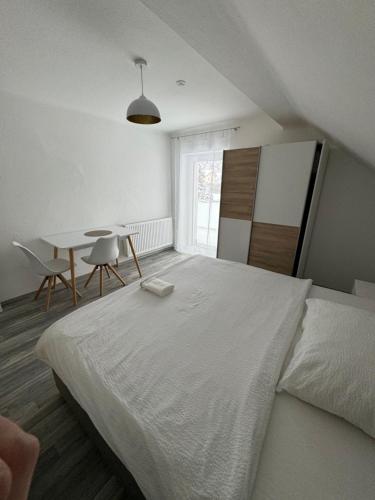 a bedroom with a large white bed and a table at Apartment Vlora 2-Naturblick in Villach