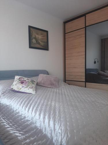 Una cama blanca con una almohada encima. en Apartament Renii, en Tomaszów Mazowiecki