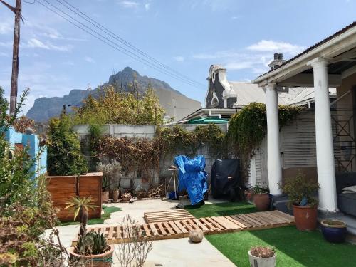 a garden with a house with a mountain in the background at Cozy Private En Suite Studio in Cape Town