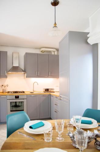 a kitchen with a wooden table and blue chairs at Ballatoio Apartment by the Lake in Lesa