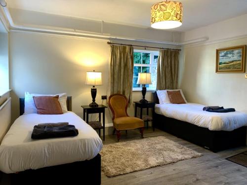 a hotel room with two beds and a chair at Moortown House in Market Rasen