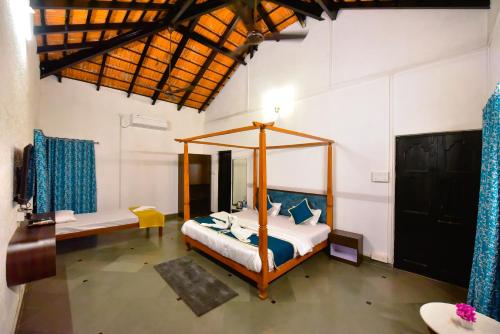 - une chambre avec un lit à baldaquin dans l'établissement ILIF 2707 Baywatch Villa - Sea side Elegance, à Nagaon