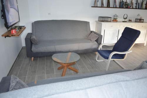 a living room with a couch and a table and chairs at Joinville : Grange entièrement rénovée style loft. in Joinville