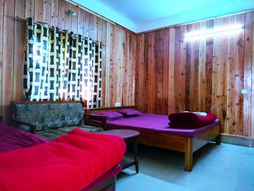 a room with two beds and a couch in it at Hotel Green Gold Resort Lataguri in Lataguri