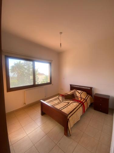 een slaapkamer met een bed en een groot raam bij Villa Ariadni in Pissouri