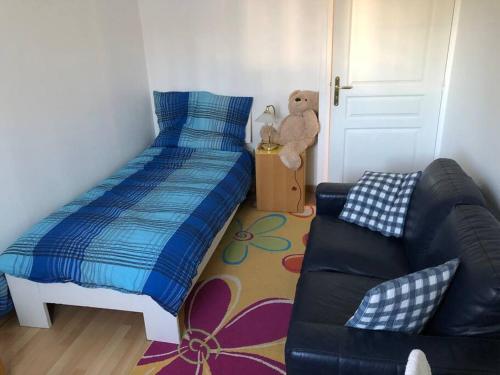 - une chambre avec un lit, un canapé et un ours en peluche dans l'établissement Au Clos Célestin - Beau T4 - Terrasse - Jardin, à Annemasse