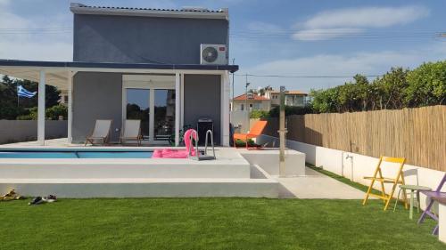 a backyard with a swimming pool and a house at Feel like Home Villa in Schinias
