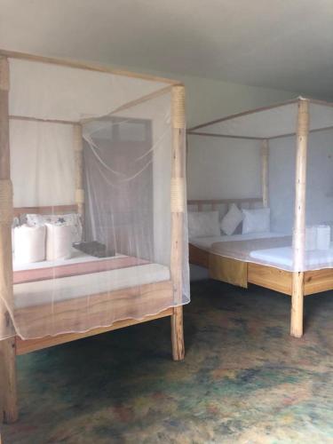 two wooden bunk beds in a room withthritisthritisthritisthritisthritisthritisthritisthritis at Jua Manyara Lodge & Camp Site in Mto wa Mbu