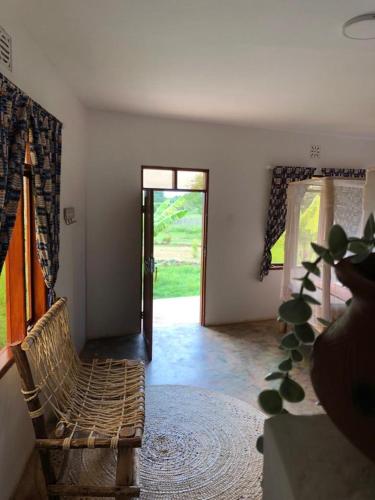 a living room with a chair and a door at Jua Manyara Lodge & Camp Site in Mto wa Mbu
