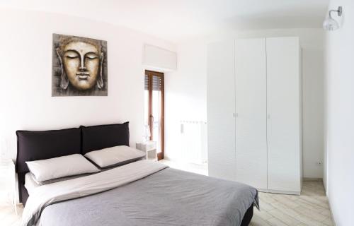 a bedroom with a bed with a face on the wall at Ballatoio Apartment by the Lake in Lesa