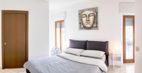 a bedroom with a bed with a mask on the wall at Ballatoio Apartment by the Lake in Lesa