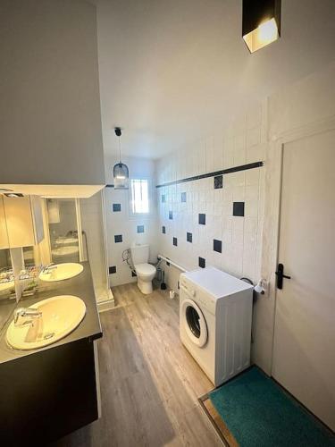 een badkamer met een wasmachine en een wasmachine. bij Appartement dans maison in Tassin-la-Demi-Lune