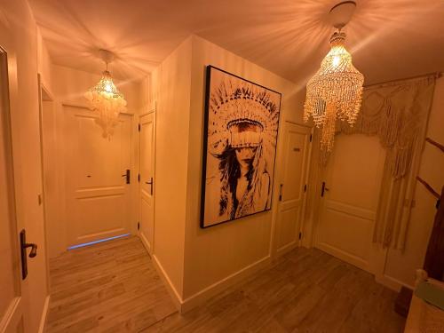 un corridoio con due lampadari a braccio e un dipinto sul muro di TOP appartement met garage "Au Franelle" a Ostenda