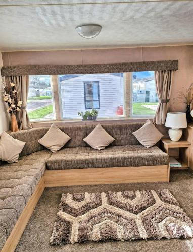 a large couch in a living room with a window at 35 Irby way in Skegness