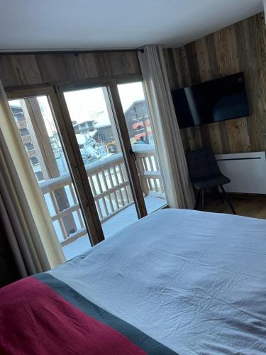 une chambre avec un lit et une vue sur un balcon dans l'établissement Les Carroz d'Araches, aux Carroz d'Arâches