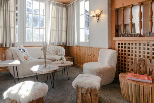 a living room with a couch and a chair and tables at Le Chalet d'Antoine - Centre de Megève in Megève