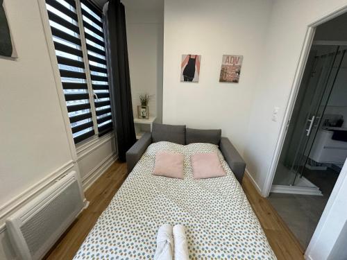 une chambre avec un lit avec deux oreillers dessus dans l'établissement A la broche - 293, à Rouen