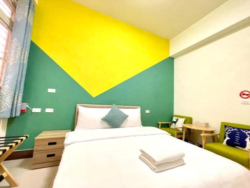 a bedroom with a bed and a yellow and green wall at Banshan Yunxiu Homestay in Jinning