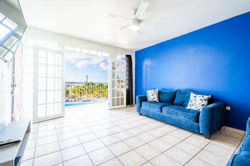 a living room with blue walls and a blue couch at West Coast Inn's in Boqueron