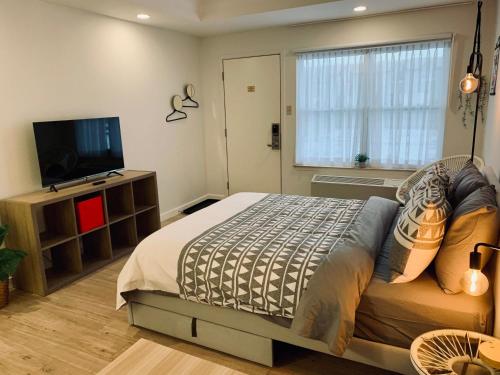a bedroom with a bed and a flat screen tv at Urban Nest, Studio, Ground Floor in Halifax