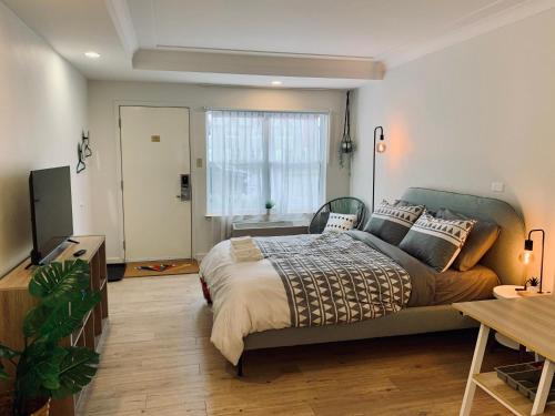 a bedroom with a large bed and a window at Urban Nest, Studio, Ground Floor in Halifax
