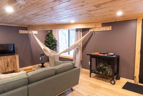 a living room with a couch and a hammock at Peaceful Naples Cabin with Deck and Stream Views in Naples