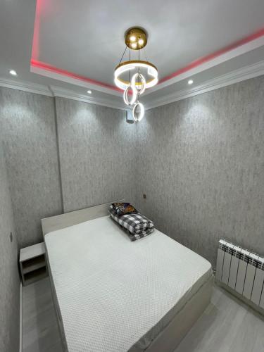 una stanza con un letto e un lampadario di DomuVista a Baku
