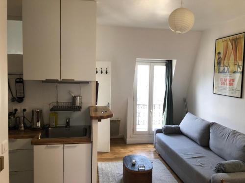 un salon avec un canapé et une cuisine dans l'établissement 2 pièces sous les toits 6 personnes calme lumineux équipé, à Paris