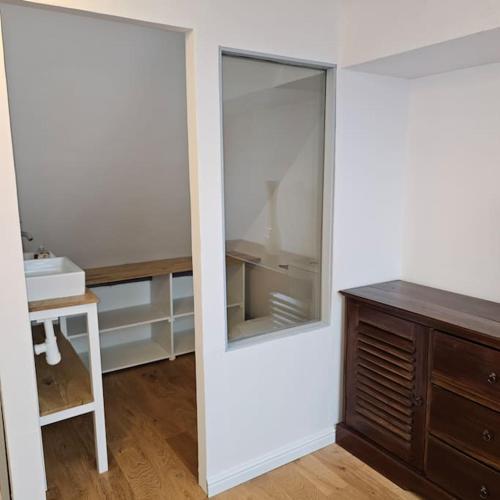 une salle de bain avec un miroir et un lavabo dans l'établissement Maison lumineuse entre mer et campagne 6 personnes, à Plouguerneau