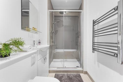 bagno bianco con doccia e servizi igienici di Modern One Bedroom Flat - Near Heathrow, Windsor Castle, Thorpe Park - Staines London TW18 a Londra