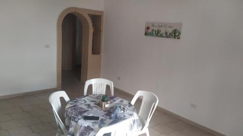 mesa de comedor con sillas y una foto en la pared en Lino's house, en Adrano