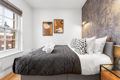 una camera da letto con un grande letto con cuscini bianchi e neri di Modern One Bedroom Flat - Near Heathrow, Windsor Castle, Thorpe Park - Staines London TW18 a Londra